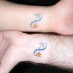 Matching wrist tattoos with sun, moon, and infinity sign.